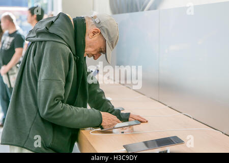 Ein älterer Mann blickt auf ein Tablet iPad im Apple Store an Manhattans Upper West Side. Stockfoto