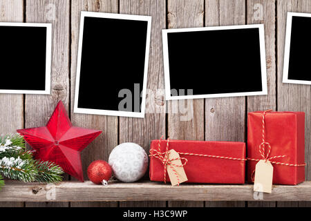 Weihnachtsbilderrahmen, Geschenk-Boxen und Tanne vor Holzwand. Zeigen mit textfreiraum an Stockfoto