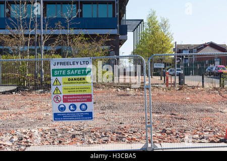 Abriss-Website-Sicherheit bemerken auf dem geräumten Gelände des ehemaligen AJ Cafe, Albert Road, Farnworth. Gebäude nach Brand abgerissen. Stockfoto