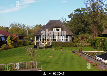 Strohgedeckten Timber Lodge am Ufer des Flusses Bure Norfolk Broads Stockfoto