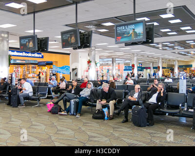 Menschen sitzen und warten auf Fort Lauderdale Hollywood International Airport in Florida, USA Stockfoto