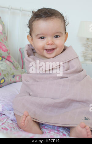 Baby in ein Handtuch gewickelt, Lächeln, Porträt Stockfoto