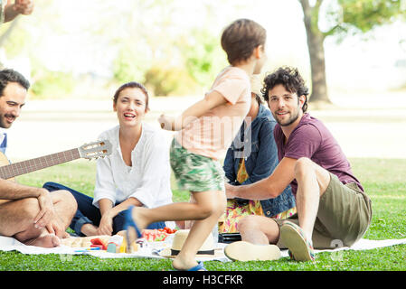 Familien genießen Picknick im Park, junge herumlaufen Stockfoto