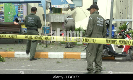 Thailändische Polizei Tatort Ermittler suchen in der Nähe der Uhrturm auf dem Gelände der zweiten Explosionen in Hua Hin, Thailand 12 Stunden nach der ersten. Eine Serie von koordinierten Blasten in Südthailand einschließlich Hua Hin und Phuket mindestens vier Menschen und verletzte Dutzende über einen Zeitraum von 24 Stunden zu töten. Berichten zufolge keine Gruppe hat behauptet, die Angriffe aber Verdacht auf separatistische Rebellen gefallen. Stockfoto