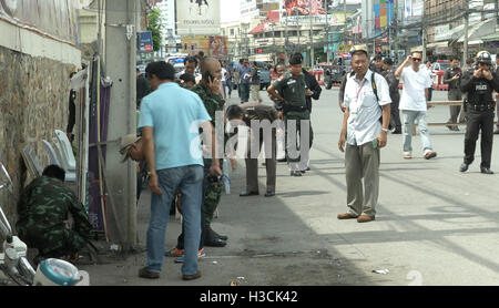 Thailändische Polizei Tatort Ermittler suchen in der Nähe der Uhrturm auf dem Gelände der zweiten Explosionen in Hua Hin, Thailand 12 Stunden nach der ersten. Eine Serie von koordinierten Blasten in Südthailand einschließlich Hua Hin und Phuket mindestens vier Menschen und verletzte Dutzende über einen Zeitraum von 24 Stunden zu töten. Berichten zufolge keine Gruppe hat behauptet, die Angriffe aber Verdacht auf separatistische Rebellen gefallen. Stockfoto