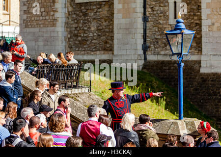 Ein Beefeater (Yeoman Of The Guard) geben eine Tour auf den Tower Of London, London, England Stockfoto