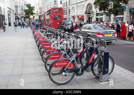 Eine Reihe von Santander Bank gesponsert Fahrräder von Londons Fahrrad Verleih Regelung, die ein beliebtes Transportmittel für Touristen sind. Stockfoto