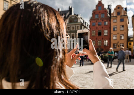 Ein Tourist, ein Foto mit ihrem Handy, Stortorget in Gamla Stan, Stockholm, Schweden. Stockfoto