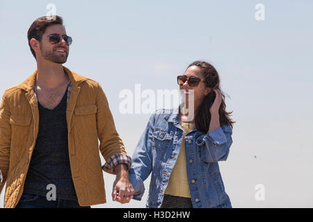 Glückliches Paar Hand in Hand stehen gegen klaren Himmel an sonnigen Tag Stockfoto