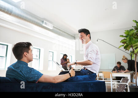 Glücklich Kaufmann diskutieren mit Kollegen in Kreativbüro Stockfoto