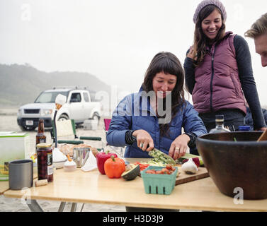 Freunde, die Zubereitung am Tisch am Strand Stockfoto