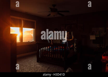 Man putzt sich Sohn im Schlafzimmer zu Hause Stockfoto