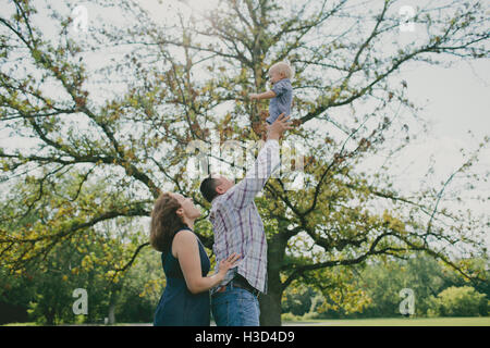 Glücklicher Vater werfen Babyjungen in Luft Stockfoto