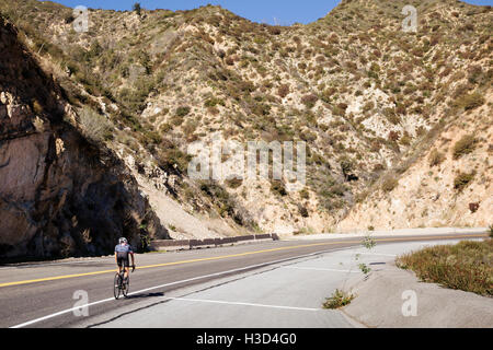 Mann auf Straße von majestätischen Berg Radfahren Stockfoto