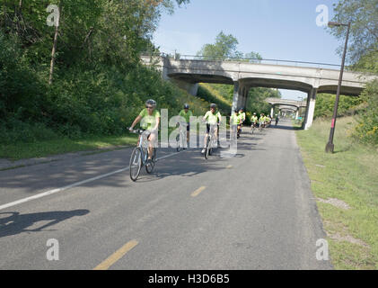 Gruppe von grünen Hemden Schlossmühle reisen hinunter die Midtown Greenway Radweg. Minneapolis Minnesota MN USA Stockfoto