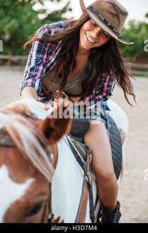 Fröhliche hübsche junge Frau Cowgirl Reiten im Dorf genießen Stockfoto