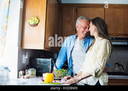 Lächelnd älteres paar stehen in einer Küche, Zubereitung von Speisen. Stockfoto