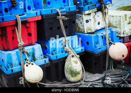 Ein Stapel von Kunststoff Fischkästen und Fischerei Schwimmer. Stockfoto