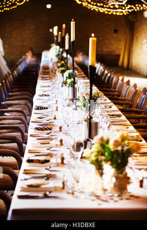 Ein Ort für Hochzeiten dekoriert für eine Party mit Lichterketten und einem langen Tisch zum Abendessen. Stockfoto