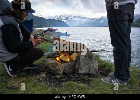 Freunde bauen Sie ein Feuer am Ufer eines Sees in innen Britisch-Kolumbien Stockfoto