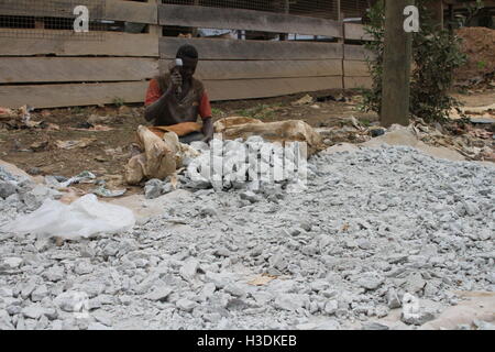 Brong-Ahafo, Ghana. 15. Sep, 2016. Ein Jüngling sitzt durch einen Haufen von Steinen, gold Erz in einer Goldmine in Brong-Ahafo, Ghana, 15. September 2016 enthält. Foto: KRISTIN PALITZA/DPA/Alamy Live-Nachrichten Stockfoto