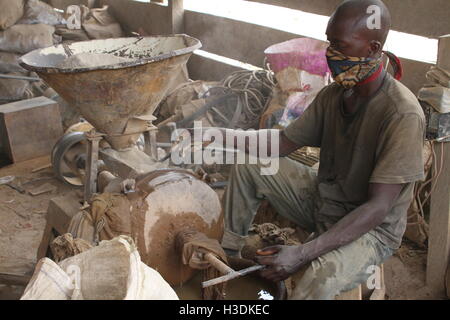 Brong-Ahafo, Ghana. 15. Sep, 2016. Ein Arbeiter sitzt auf einer Maschine, die mit gold Erz in einer Goldmine in Brong-Ahafo, Ghana, 15. September 2016 Felsen zermalmt. Das Werk erzeugt große Mengen an Staub. Foto: KRISTIN PALITZA/DPA/Alamy Live-Nachrichten Stockfoto