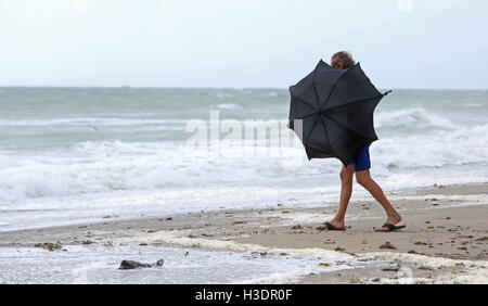 Hollywood, FL, USA. 6. Oktober 2016. Ein Strand-Goer entlang Hollywood Beach versucht, seinen Regenschirm als starke Winde vom Hurrikan Matthew Ansatz Südflorida offenzuhalten. Bildnachweis: Sun-Sentinel/ZUMA Draht/Alamy Live-Nachrichten Stockfoto