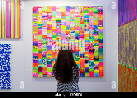 London, UK.  6. Oktober 2016. Ein Besucher Ansichten Werke des Künstlers, Colin McCallum in der Abend-Vorschau der Moniker Art Fair, Teil der London Art Week, statt an die Old Truman Brewery, in der Nähe von Brick Lane.  Jetzt in seinem siebten Jahr umfasst die Messe zeitgenössischen Kunst von aufstrebenden und etablierten Künstlern, von denen die Mehrheit die Messe persönlich besuchen, um potenzielle Sammler gerecht zu werden und ihre Arbeit zu zeigen.  Bildnachweis: Stephen Chung / Alamy Live News Stockfoto