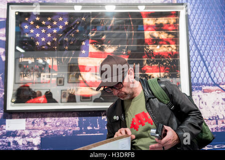 London, UK.  6. Oktober 2016. Ein Besucher Blick auf Kunstwerke in der Abend-Vorschau der Moniker Art Fair, Teil der London Art Week, statt auf die Old Truman Brewery, in der Nähe von Brick Lane.  Jetzt in seinem siebten Jahr umfasst die Messe zeitgenössischen Kunst von aufstrebenden und etablierten Künstlern, von denen die Mehrheit die Messe persönlich besuchen, um potenzielle Sammler gerecht zu werden und ihre Arbeit zu zeigen.  Bildnachweis: Stephen Chung / Alamy Live News Stockfoto