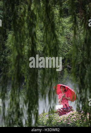 Los Angeles, Kalifornien, USA. 10. September 2016. Eine Frau geht Vergangenheit Weiden im Nebel Mengqingyuan Green Theme Park in Shanghai, China gehüllt. Shanghai ist die bevölkerungsreichste Stadt in China und der eigentlichen bevölkerungsreichste Stadt in der Welt. Es ist eines der vier direkt gesteuerte Gemeinden Chinas, mit einer Bevölkerung von mehr als 24 Millionen ab 2014. Es ist ein globales Finanzzentrum und ein Verkehrsknotenpunkt mit der größte Containerhafen der Welt. Der Jangtse-Delta im Osten Chinas befindet, sich im Shanghai am Südrand der Mündung des Jangtse im mittleren Teil des t Stockfoto