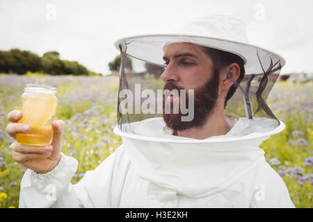 Halten Sie eine Flasche Honig Imker Stockfoto