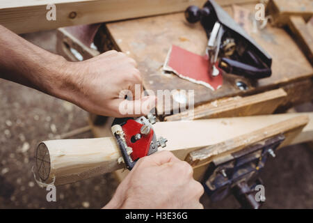 Mann mit einem handheld Werkzeug zum Glätten und ebnen die Oberfläche eine Planke Stockfoto