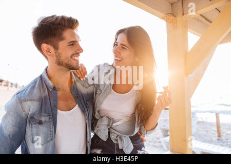 Schönes Lachen junges Paar sahen einander stehen am Strand Stockfoto