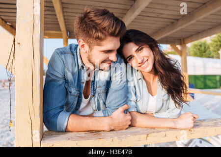 Junge schöne Frau, stützte sich auf die Schulter Freund im stehen in die hölzernen Strandhaus Stockfoto