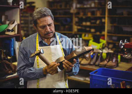 Schuhmacher Hämmern auf einen Schuh Stockfoto
