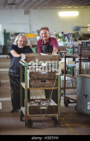 Glasbläser und ein Kollege Wagen schieben Stockfoto