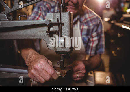 Schuhmacher mit Nähmaschine Stockfoto