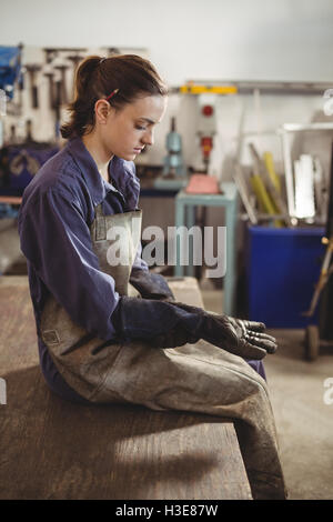 Weibliche Schweißer tragen Handschuh Stockfoto