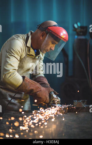 Männliche Schweißer arbeiten an einem Stück Metall Stockfoto