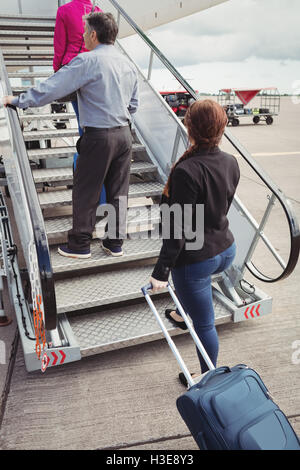 Passagiere auf der Treppe klettern und das Flugzeug betreten Stockfoto