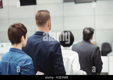 Passagiere warten in der Schlange am Check-in-Schalter mit Gepäck Stockfoto