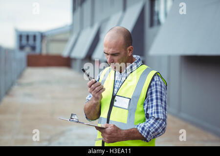 Bauarbeiter am Walkie-talkie sprechen Stockfoto