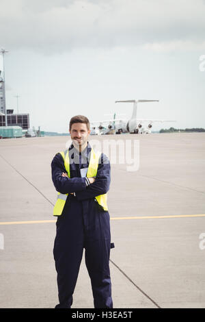 Porträt von Flughafen Bodenpersonal stehend mit Armen gekreuzt Stockfoto