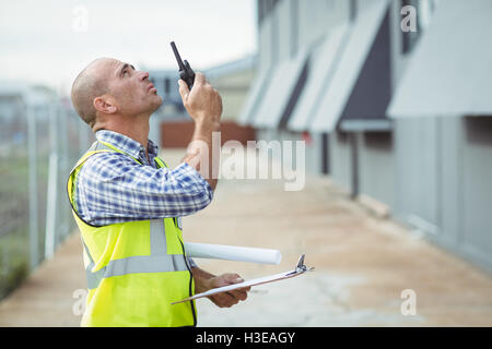 Bauarbeiter am Walkie-talkie sprechen Stockfoto