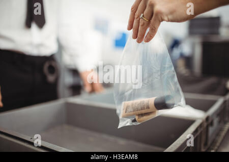 Passagier putting Plastiktüte in Fach für Sicherheit überprüfen Stockfoto