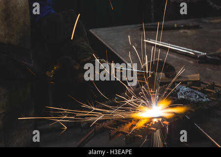 Mittleren Teil des weiblichen Schweißer arbeiten an einem Stück Metall Stockfoto