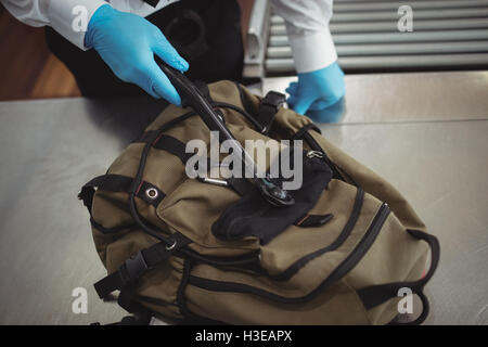 Flughafen-Security-Officer mit einem Metall-Detektor, ein Gepäckstück aufgeben Stockfoto