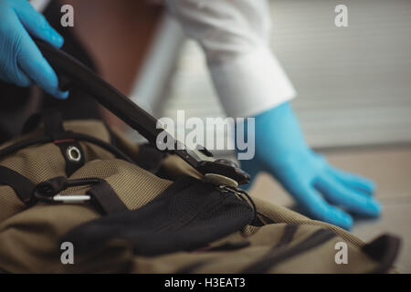 Flughafen-Security-Officer mit einem Metall-Detektor, ein Gepäckstück aufgeben Stockfoto