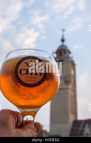 Ein bedrucktes Glas ti Ch'Lagerbier, mit Blick auf den Belfried, Bergues, Nord-Pas-de-Calais, Ile de France, Frankreich pub Tabelle getränke Gläser Stockfoto