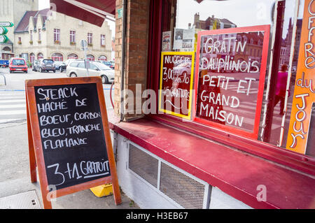 Angebote auf dem Fenster von einer französischen Metzgerei, Bergues, Nord-Pas-De-Calais, Hauts-de-France, Frankreich Stockfoto